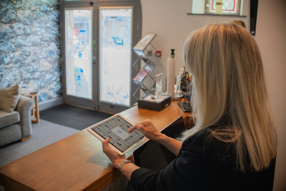 Receptionist using a tablet at the front desk